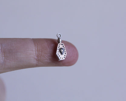 pendentif en argent en forme de fiole de poison avec un crâne dessus