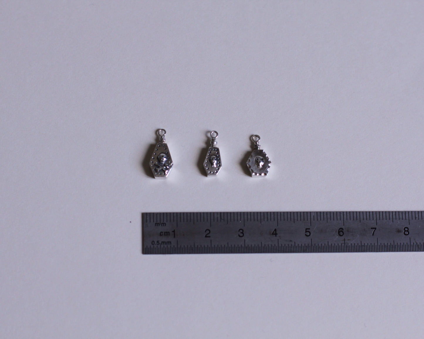 trois pendentifs représentant des fioles de poison en argent massif