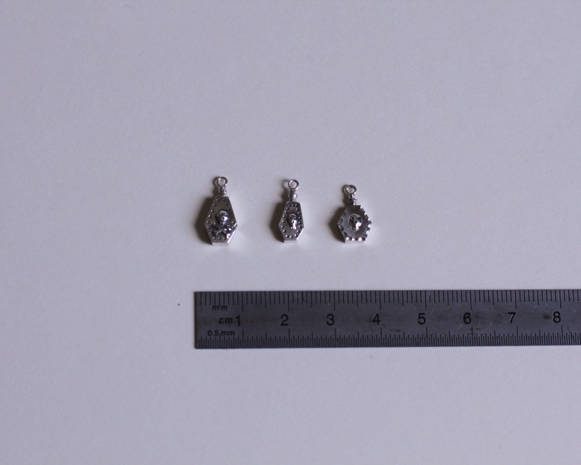 trois pendentifs représentant des fioles de poison en argent massif