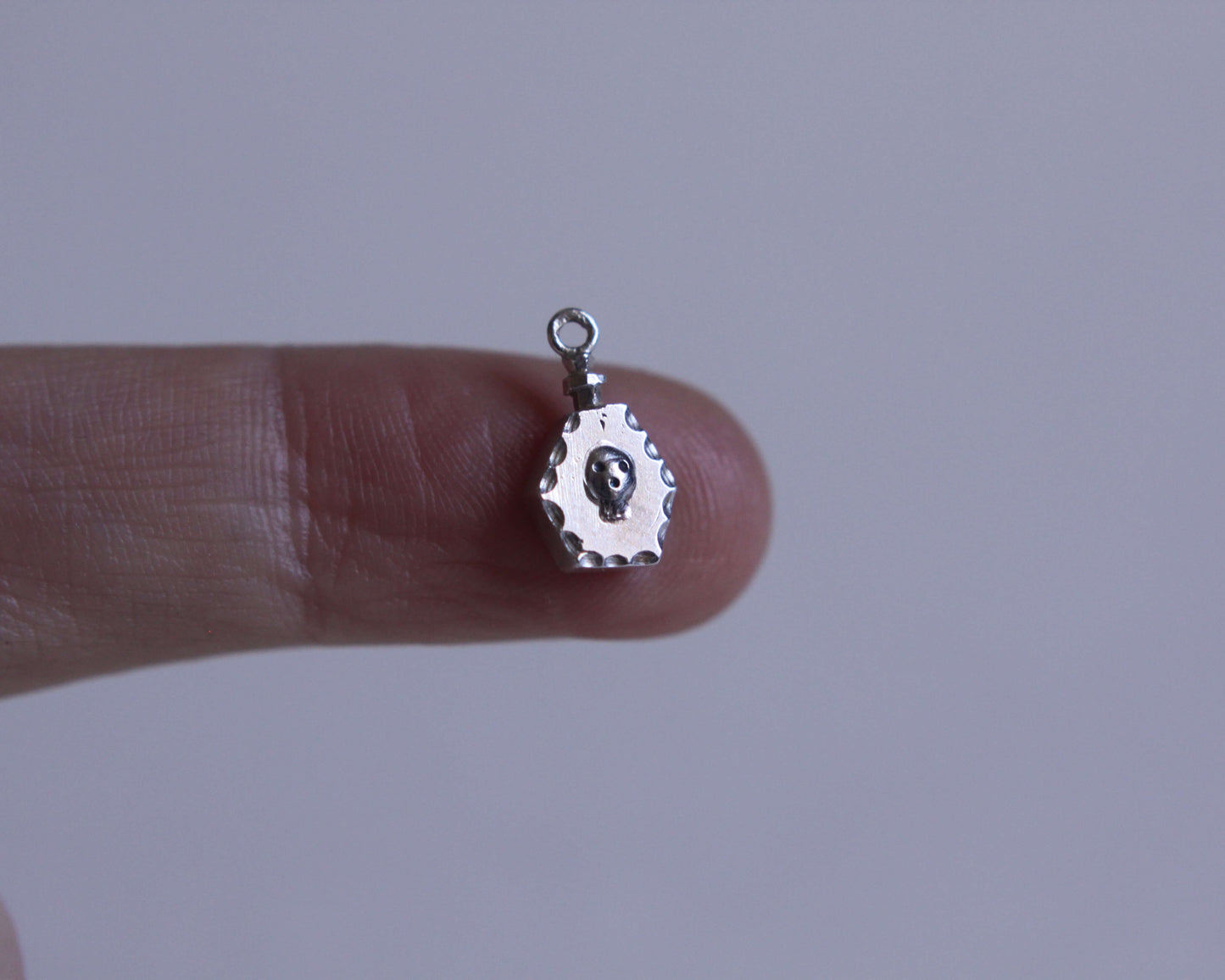 pendentif en argent massif en forme de fiole de poison avec un crâne dessus