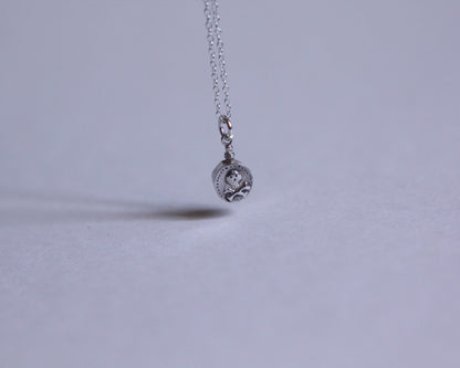 petit pendentif en argent en forme de fiole de poison décoré d'une tête de mort