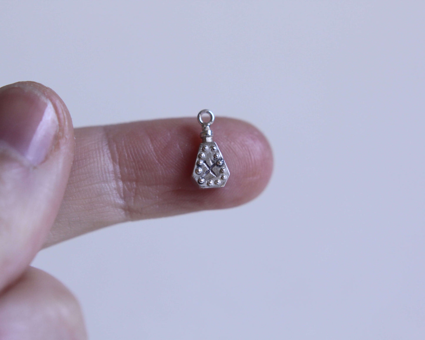 pendentif en argent massif en forme de fiole de poison avec une croix dessus