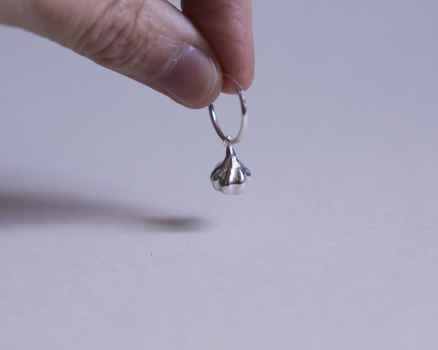 pendentif en forme de gousse d'ail en argent massif accrochée à un anneau