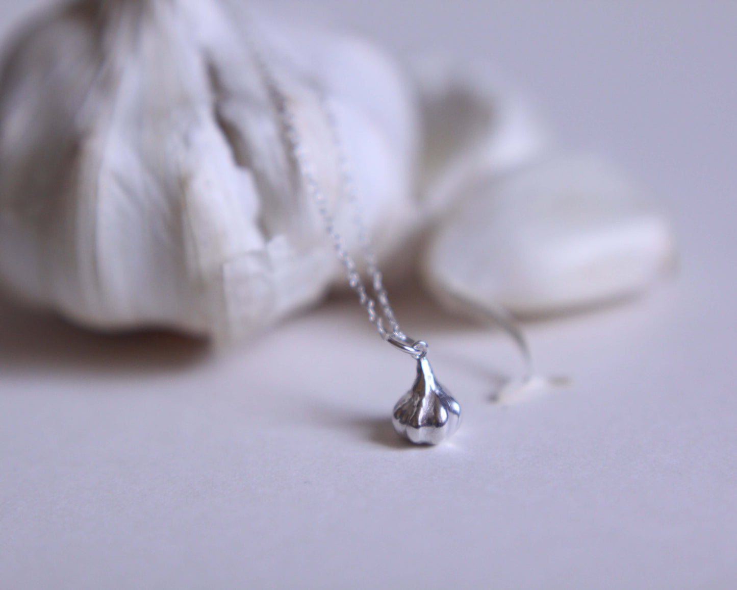 zoom sur un pendentif en argent massif en forme de gousse d'ail
