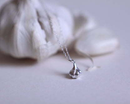 zoom sur un pendentif en argent massif en forme de gousse d'ail