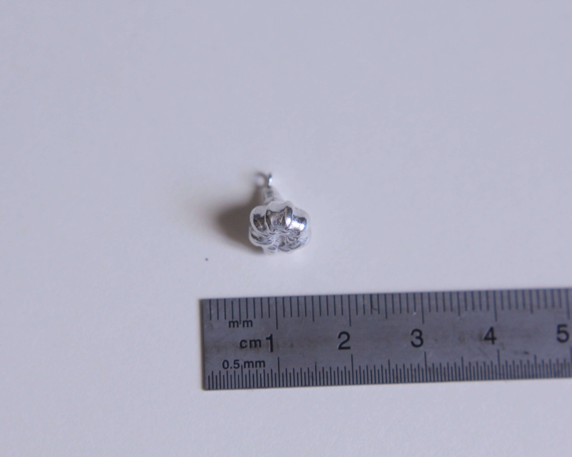pendentif en argent massif représentant une gousse d'ail avec une règle à coté