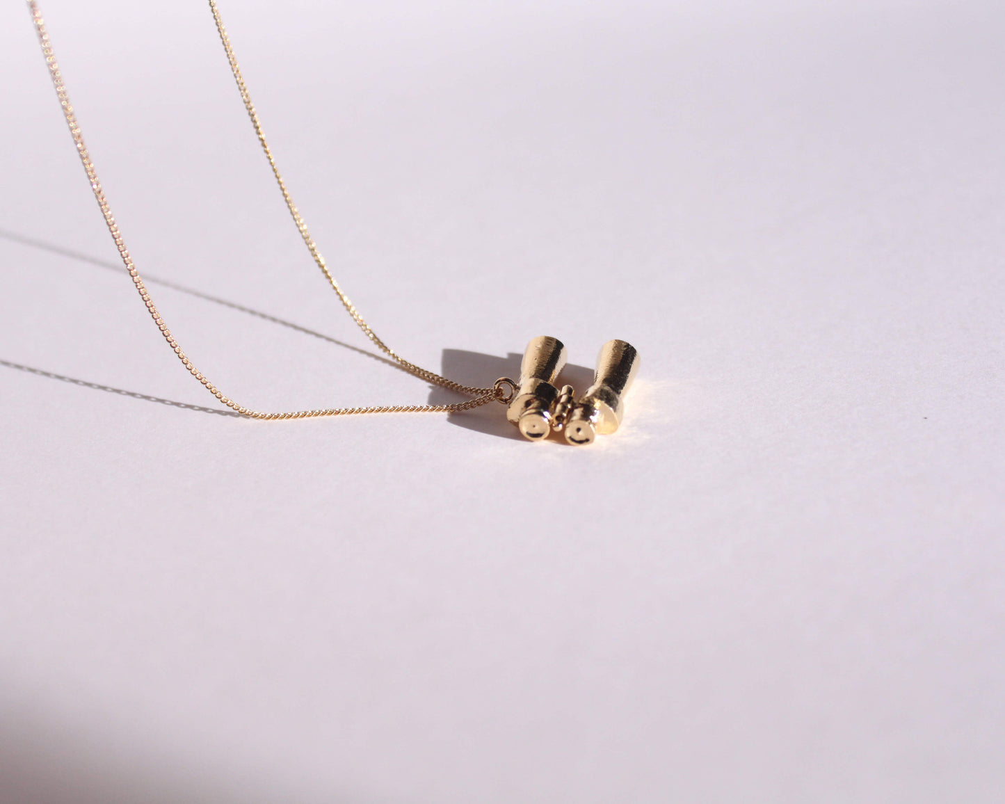 collier avec pendentif en laiton plaqué or représentant une paire de jumelles