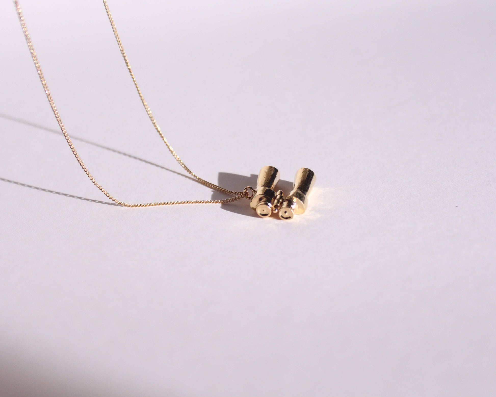 collier avec pendentif en laiton plaqué or représentant une paire de jumelles