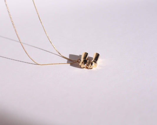 collier avec pendentif en laiton plaqué or représentant une paire de jumelles