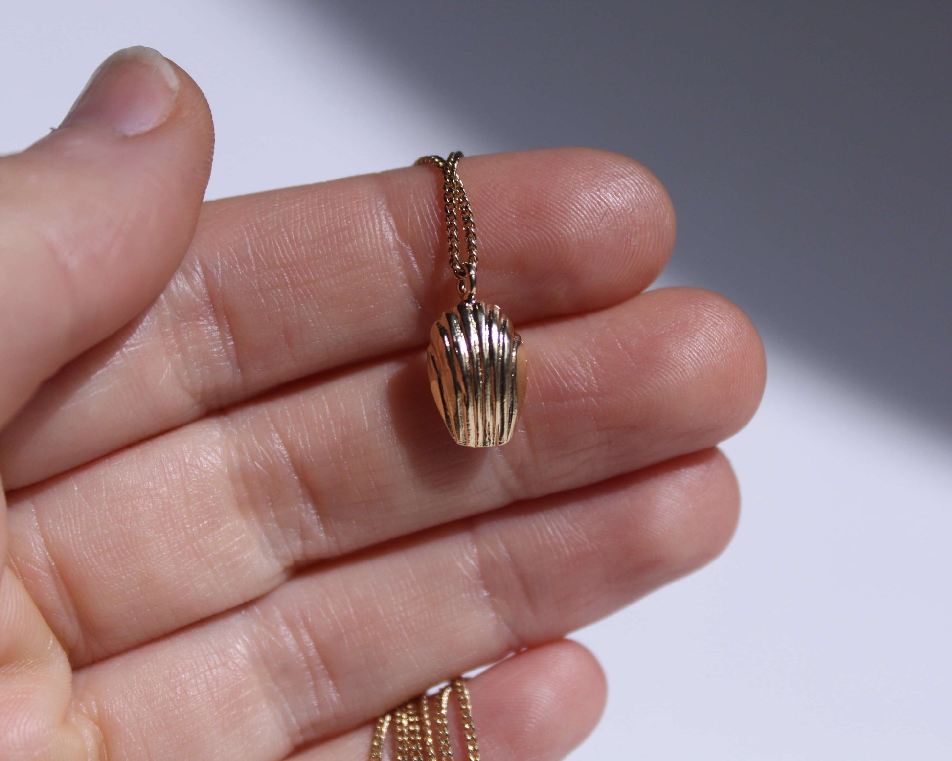 collier avec un pendentif en laiton plaqué or en forme de madeleine