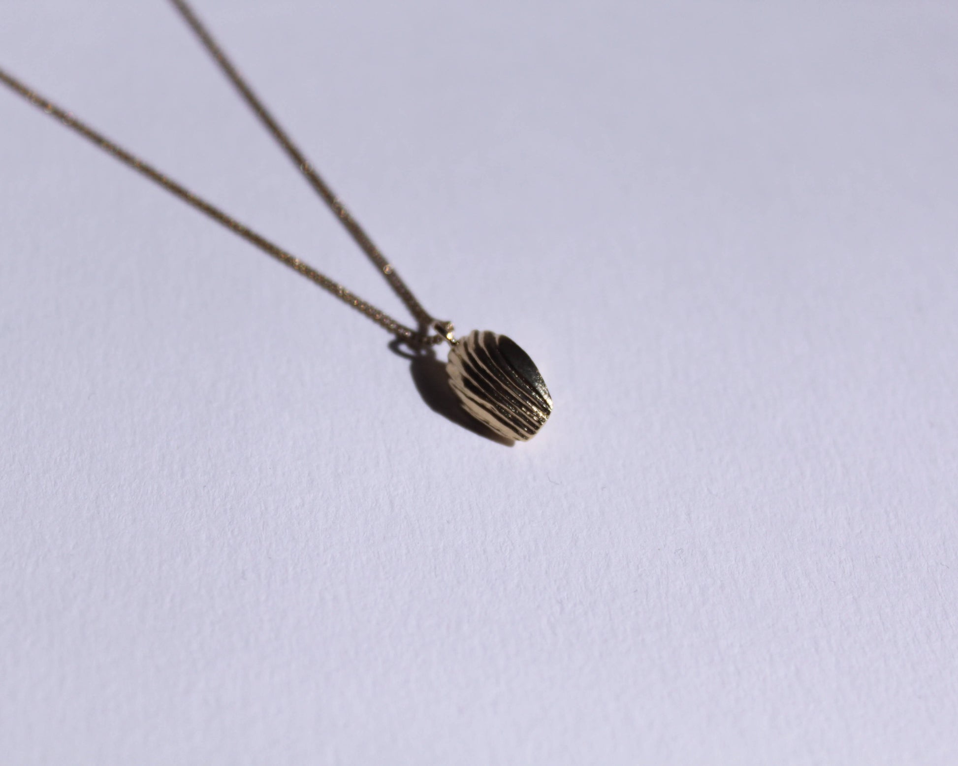 dessous d'un pendentif en laiton plaqué or en forme de madeleine