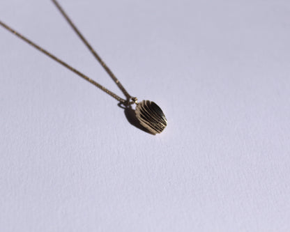 dessous d'un pendentif en laiton plaqué or en forme de madeleine