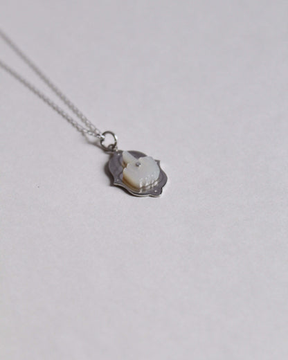 collier pendentif en forme de doigt d'honneur en nacre sculptée