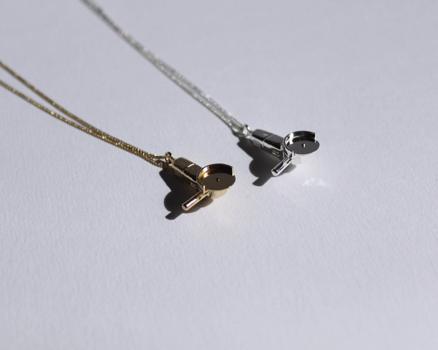 pendentifs en laiton plaqué or et en argent massif, symbolisant des meuleuses, au bout d'une chaine