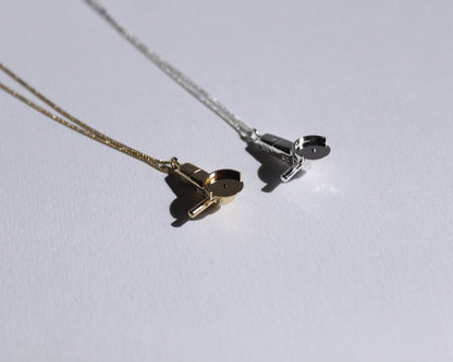 pendentifs en laiton plaqué or et en argent massif, symbolisant des meuleuses, au bout d'une chaine