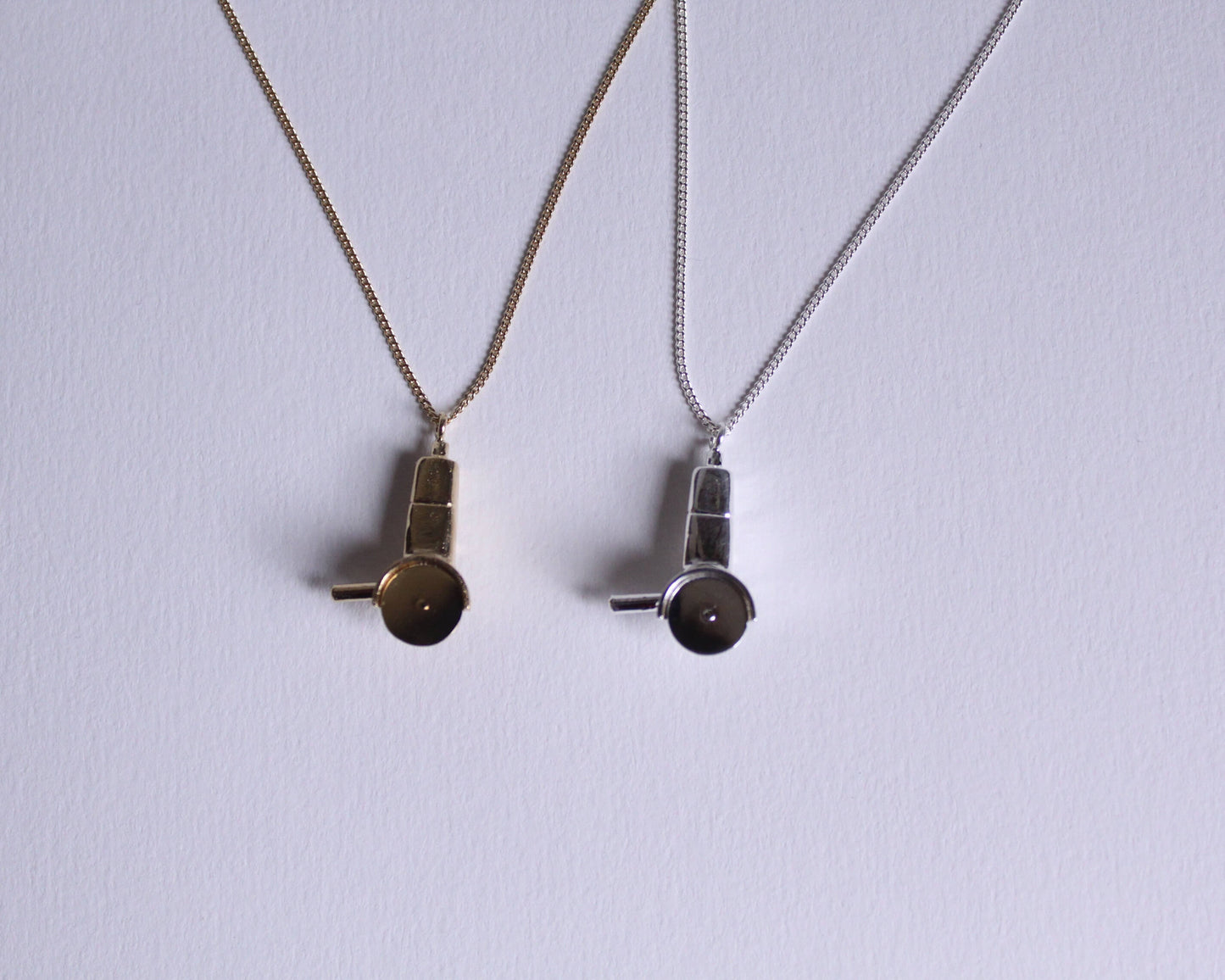 colliers avec des pendentifs en laiton plaqué or et en argent massif en forme de meuleuses dont la lame tourne