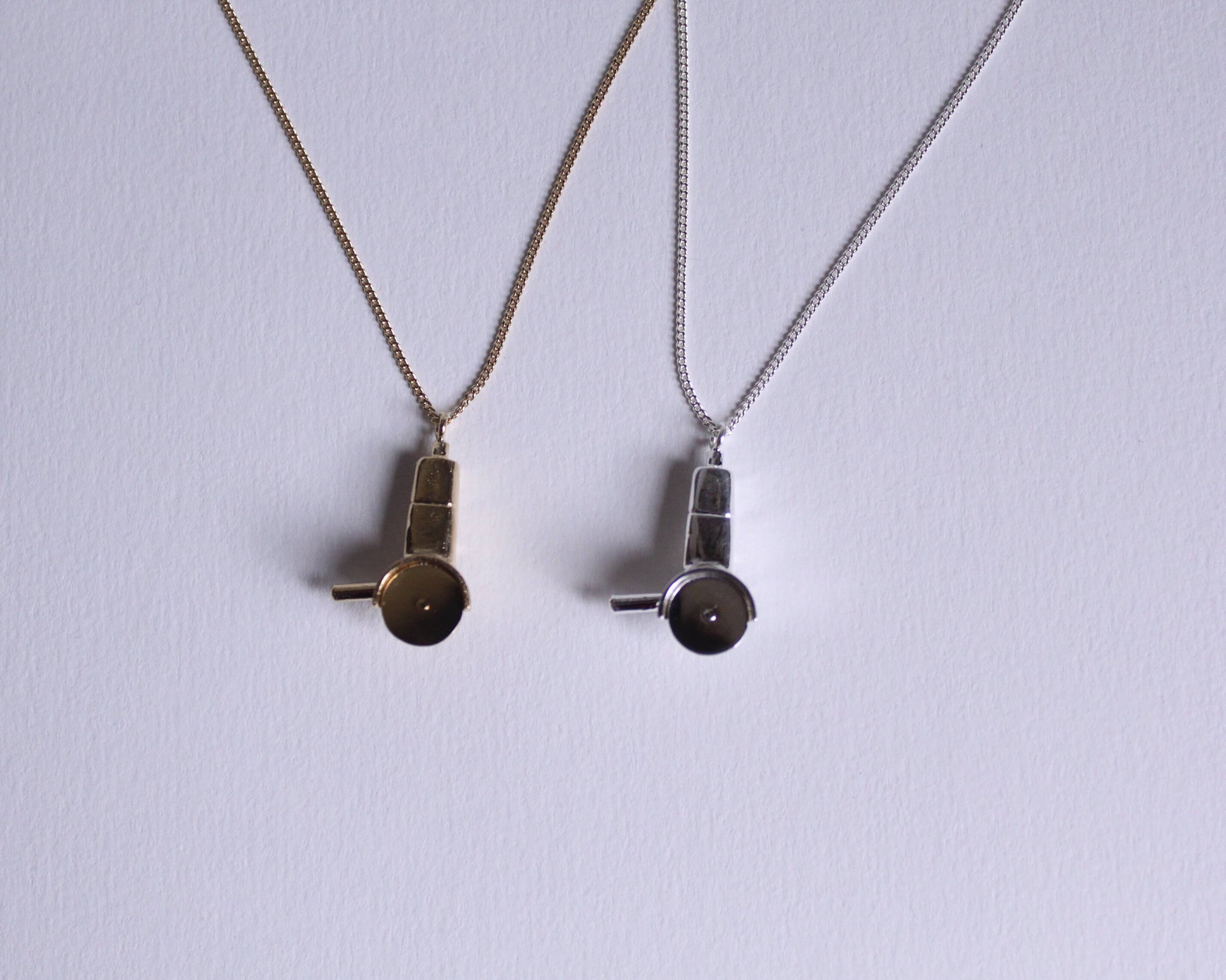 colliers avec des pendentifs en laiton plaqué or et en argent massif en forme de meuleuses dont la lame tourne