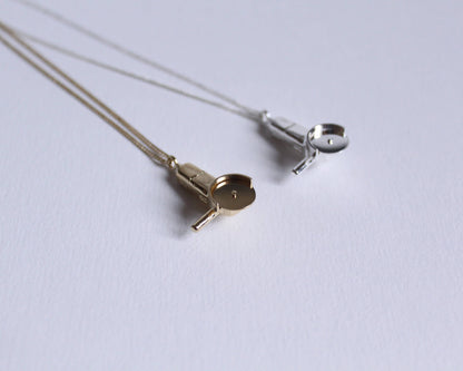 collier avec pendentifs en argent massif et en laiton plaqué or symbolisant des meuleuses