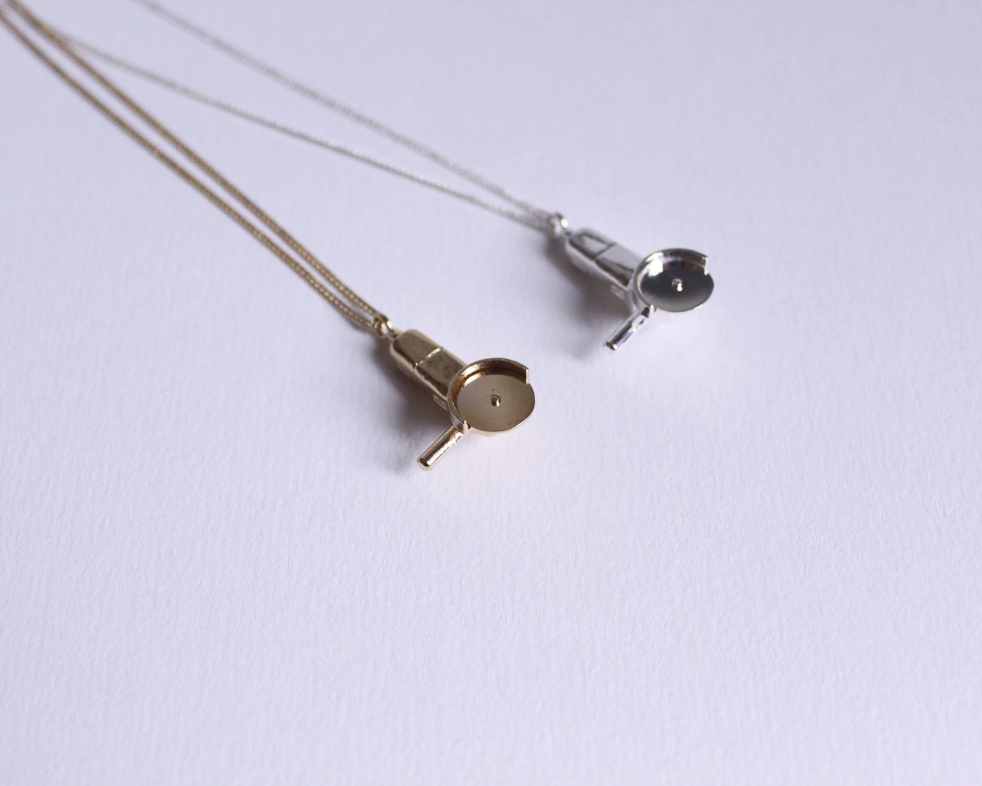 deux colliers avec des pendentifs en forme de meuleuses