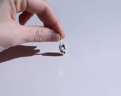 petit pendentif en forme de poêlon à raclette avec du fromage qui dégouline