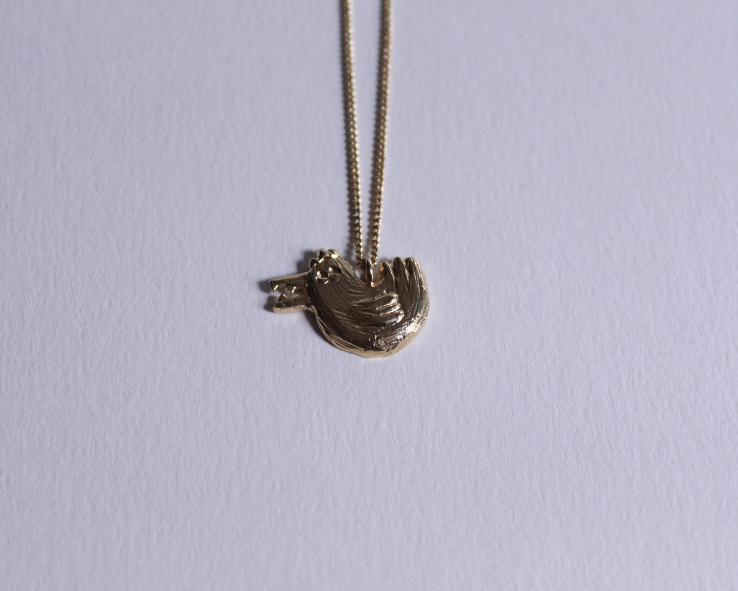 pendentif en laiton plaqué or en forme de poule avec des dents dans le bec