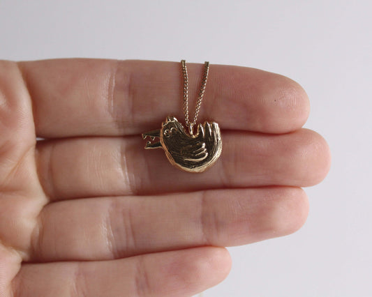 pendentif en forme de poule disposant d'un bec avec des dents dedans 