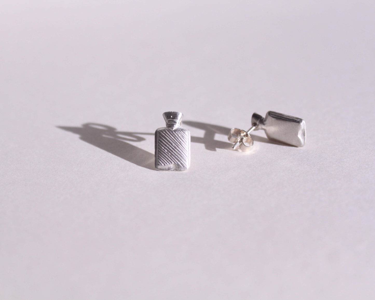 vue détaillée de puces d'oreilles en argent massif symbolisant des bouillottes